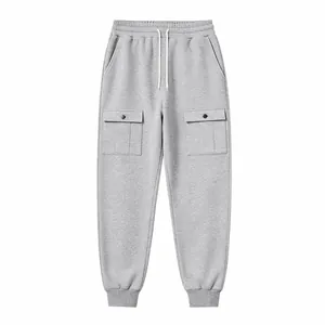 Close-up view of grey cargo sweatpants featuring a drawstring waist and large button flap pockets