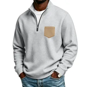 Detail view of men's grey half-zip sweatshirt with tan chest pocket and fleece lining
