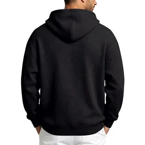 Detailed rear view of men's black waffle-knit hoodie showcasing premium fabric texture