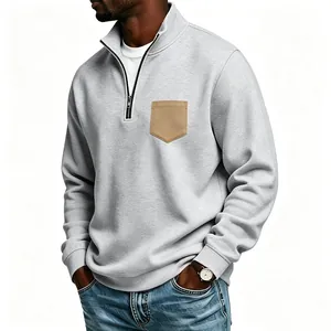 Detailed view of a grey men's quarter-zip sweatshirt featuring a stylish tan chest pocket
