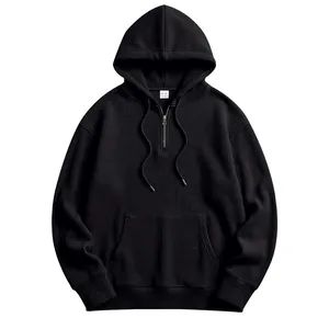 Macro view of black waffle knit hoodie featuring half-zip design and kangaroo pocket