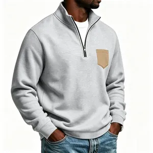 Macro view of a gray fleece sweatshirt featuring a contrast tan patch pocket detail