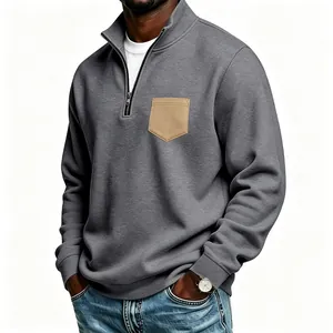 Close-up of men's gray half-zip sweatshirt with a tan chest pocket detail.