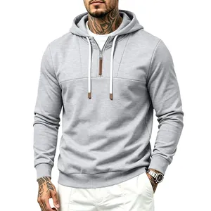 Dettaglio felpa con cappuccio grigia da uomo con mezza zip, lacci bianchi e inserti in pelle