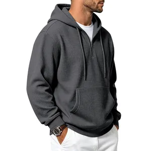 Close-up detail of a men's waffle knit hoodie with a half-zip and drawstring hood
