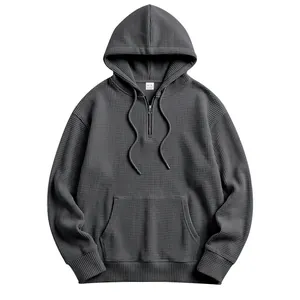 Close-up of men's dark gray waffle knit hoodie with half-zip and drawstring detail