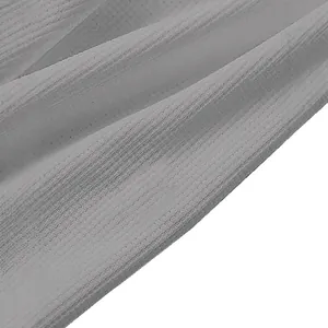 Close-up of grey waffle knit long sleeve Polo shirt showing detailed fabric texture