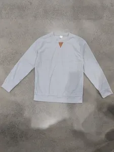 Gedetailleerde weergave van het lichtblauwe corduroy sweatshirt met bruin nekstuk.