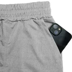 Detail view of grey athletic shorts pocket featuring a smartphone for size reference