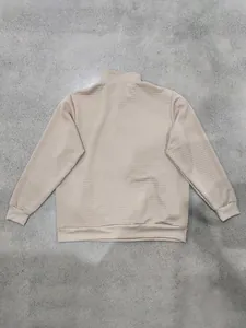 Vista trasera de sudadera de hombre beige con patrón jacquard de cuadros y puños.