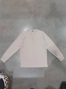 Detailed view of beige men's Henley shirt with vertical ribbed knit texture