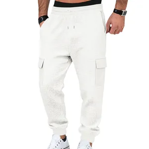 Detail view of white waffle knit cargo joggers featuring side flap pockets and drawstring