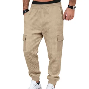 Detailed view of men's khaki waffle-knit cargo joggers with drawstring waist.