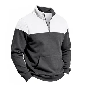 Detailed view of men's quarter-zip sweatshirt featuring quilted white and grey patchwork