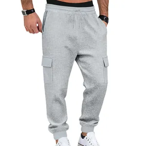 Close-up detail of light grey waffle knit cargo joggers featuring side pockets and cuffs.