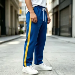 Detail of men's blue sweatpants with yellow side stripe in an urban street setting