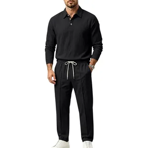 Full body shot of man wearing black linen long-sleeve polo and matching drawstring trousers.