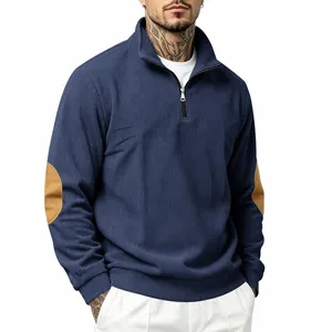 Macro view of navy blue ribbed sweatshirt featuring half-zip collar and tan elbow patches.