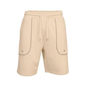 Close-up of men's beige athletic shorts with drawstring waist and pocket detail.