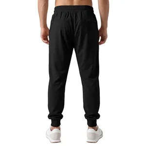 Rear view of men's black joggers featuring elastic waist and cuffed ankles for sports.