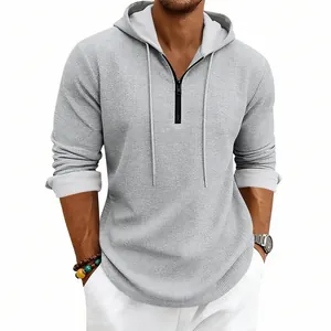 Dettaglio della felpa con cappuccio grigia da uomo in maglia a nido d'ape con mezza zip e cordino