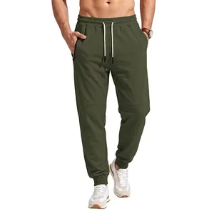 Close-up of olive green joggers featuring elastic waist with drawstring and zipper pocket.