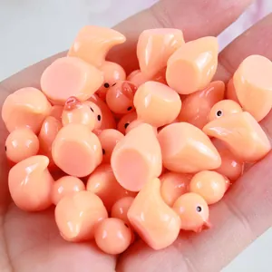 Nahaufnahme von kleinen rosa Harz-Enten in der Hand für Mikrolandschaften und DIY-Bastelarbeiten