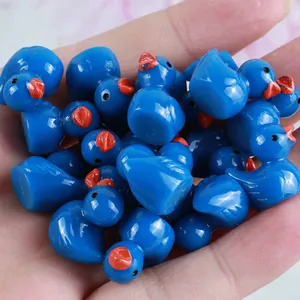 Nahaufnahme kleiner blauer Entenfiguren aus Harz für DIY-Mikrolandschaften in einer Handfläche