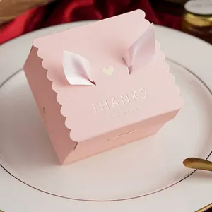 Close-up of pink square wedding candy box with silk rabbit ears and gold THANKS text
