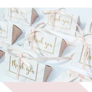 Detail of marble pattern wedding candy box with pink ribbon and thank you print