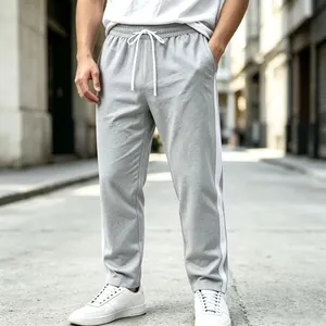 Detail of men's grey sports sweatpants with side stripes and drawstring waist