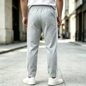 Detailed back view of grey men's joggers with white side stripes for a sporty style