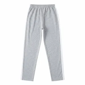 Detailed view of grey men's sports trousers featuring white side stripe details