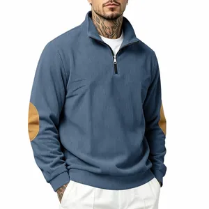 Macro view of blue ribbed sweatshirt with half-zip collar and elbow patches.