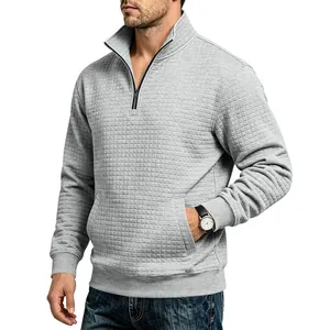 Vista detallada de una sudadera gris para hombre con media cremallera y diseño de rejilla