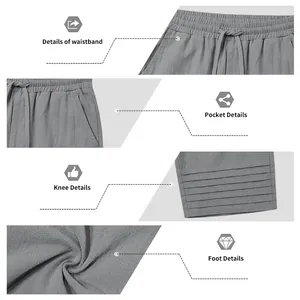 Detail view of drawstring waistband, pockets, and pleated hem on grey cotton linen pants.