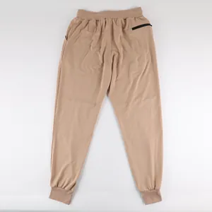 Detail view of men's beige joggers showing back zipper pocket and elastic waist.