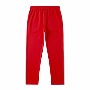Detailed view of red men's sweatpants with white side stripes and elastic waistband.