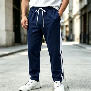 Detailed view of navy blue sweatpants with white side stripes and drawstring waist
