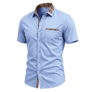 Close-up view of light blue short sleeve shirt with plaid contrast trim details
