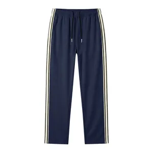 Detail view of navy blue men's joggers with white side stripes and drawstring