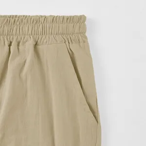 Detailed close-up of men's linen shorts showing elastic waistband and side pocket.