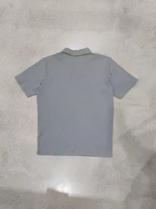 Vista posterior de polo gris para hombre con rayas verticales texturizadas de calidad