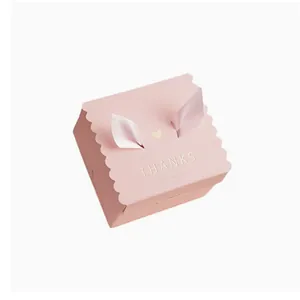 Elegant pink wedding candy gift box with scalloped edges and ribbon 'THANKS' design.