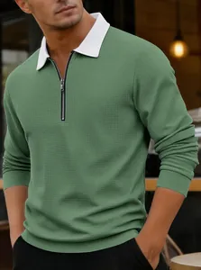 Detalle de polo de punto gofrado verde para hombre con cuello blanco y cremallera.