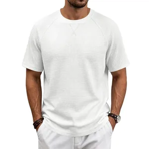 Détail précis d'un t-shirt à manches courtes en maille gaufrée blanche pour hommes.
