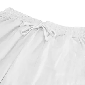 Macro view of white linen casual pants showing elastic waist and drawstring detail