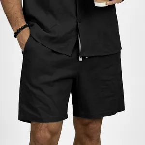 Close-up of men's casual black linen shorts with drawstring elastic waistband on model