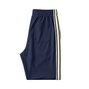 Detail view of navy blue men's joggers showing back pocket and side stripe trim