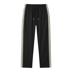 Close-up detail of men's loose sports trousers featuring side contrast stripe webbing